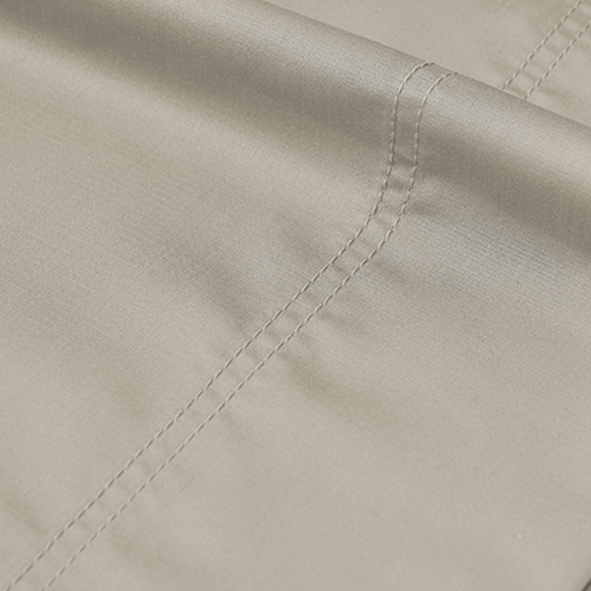 Close-up of smooth beige Egyptian Cotton Sateen sheet fabric with a double-stitched hem for luxury.
