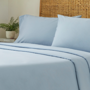 Close up of a light blue cotton duvet cover, sheet sets, & pillow cases on a bed with a headboard.